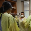 Quatre infirmières se préparent à rentrer dans un bloc opératoire.