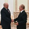 Alexandre Loukachenko et Vladimir Poutine se serrent la main en souriant.