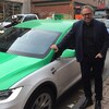 Le propriétaire de Téo Taxi, Alexandre Taillfer, prend la pose devant une voiture de la flotte.