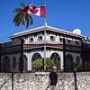 Un drapeau canadien flotte devant l'édifice clôturé de l'ambassade canadienne à Cuba.