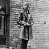Amelia Earhart devant un mur de brique. 