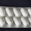 Une tablette de pilules blanches oblongues.