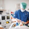 Un anesthésiste et une patiente dans un bloc opératoire. 