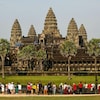 Des touristes en avant-plan regardent le site archéologique Angkor, au Cambodge. 
