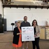 Joan Simard, Patrick Courtois et Julie Dufour tiennent une pancarte du 350e anniversaire de Chicoutimi.