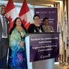 Greg Fergus, Lynn Groulx, Carol McBride et Marci Ien prennent la pose devant des drapeau du Canada.
