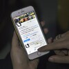 Une personne a la main sur l'écran d'un téléphone et regarde le compte de l'activiste féministe Souad al-Shammary.