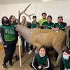 Des personnes autour d'un chevreuil artificiel.