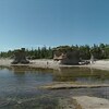 Une plage avec d'imposants monolithes de calcaires et bordée par des conifères.