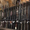Des armes de chasse disposées en ranger et à la verticale dans une boutique de chasse et pêche. 