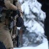 Un agent tient un fusil d'assaut. 