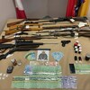 Une table sur laquelle se trouve de la drogue, de l’argent et des armes à feu.
