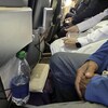Des passagers assis très près les uns des autres avec très peu d'espace pour leurs jambes.