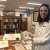 Audrey Julien, archiviste responsable au Centre d'archives du Monastère des Augustines, tient un livre ancien.