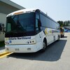 Deux autobus stationnés près d'un bâtiment. 