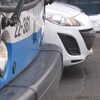 Un autobus de la STM à côté d'une voiture blanche à l'arrêt.