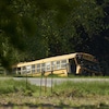 Un autobus scolaire accidenté au bord de la route après une collision.