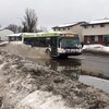 Une autobus roulant dans une flaque d'eau.