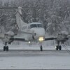 Un avion roule sur la piste de l'aéroport de Fond-du-Lac, dans le nord de la Saskatchewan, devant les arbres enneigés.