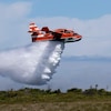 Un avion bombardier vole à basse altitude en laissant tomber l'eau.