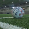 Un ballon se trouve sur un terrain de soccer vide. 