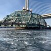 Partie centrale du pont Champlain chargée sur les barges, sur le fleuve.