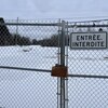 Une affiche Entrée interdite est installée sur une clôture en hiver.
