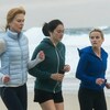 Trois femmes font du jogging sur une plage près de la mer.