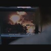 Une personne regarde un écran de télévision où une explosion se produit.