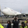 Des gens prennent un Boeing 747 en photo.