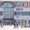 Des employés marchant devant l'édifice de Bombardier aéronautique à Montréal.