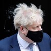 Boris Johnson, cheveux au vent, porte un masque.