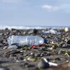 Une bouteille d'eau en plastique parmi les ordures sur une plage.