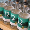 Des bouteilles du gin Km 12 de la Distillerie du Fjord reposent sur une tablette.