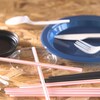 Des pailles et des ustensiles de plastique sur une table.