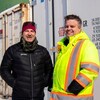 Deux hommes à côté des conteneurs. 