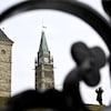 Une personne prend une photo sur la Colline du Parlement alors que le drapeau de la Tour de la Paix flotte en berne après le décès de l'ancien premier ministre Brian Mulroney, à Ottawa, le vendredi 1er mars 2024.
