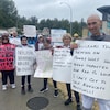 Bryce Schaufelberger et des manifestants qui tiennent des pancartes. 