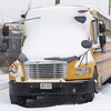 Des bus scolaires recouverts de neige.