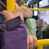 Des mains agrippent des barres à l'intérieur d'un autobus bondé.