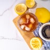 Un café avec des glaçons entouré de citrons.