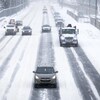 Des automobiles circulent lentement sur une route enneigée à Calgary le 7 novembre 2022.