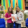 Deux petites filles de 10 ou 11 ans posent pour la caméra pour présenter un livre.