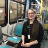 Une femme assis dans un bus de transport en commun.