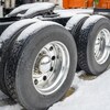 Plan rapproché des pneus d'un semi-remorque arrêté dans la neige.