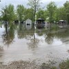 Les terrains de plusieurs campeurs sont inondés. Au loin, on voit des remises, des patios et des barbecues dans l'eau.