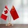 Deux drapeaux côte à côte : celui de la Chine et celui du Canada.