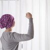 Une femme avec un foulard sur la tête fait un geste de force avec son bras.