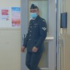 Un militaire portant un masque sort d'une pièce.