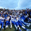 Une équipe de football universitaire pose devant l'objectif après avoir remporté la victoire.